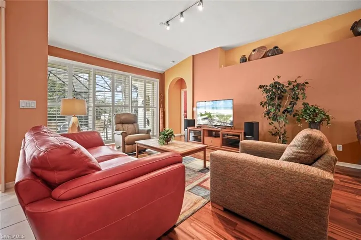 Living room with rail lighting and wood-type flooring