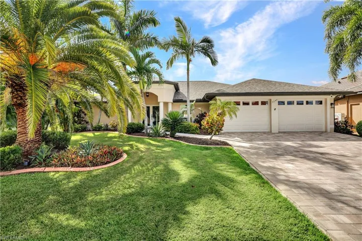 View of front of property with a front yard and a garage