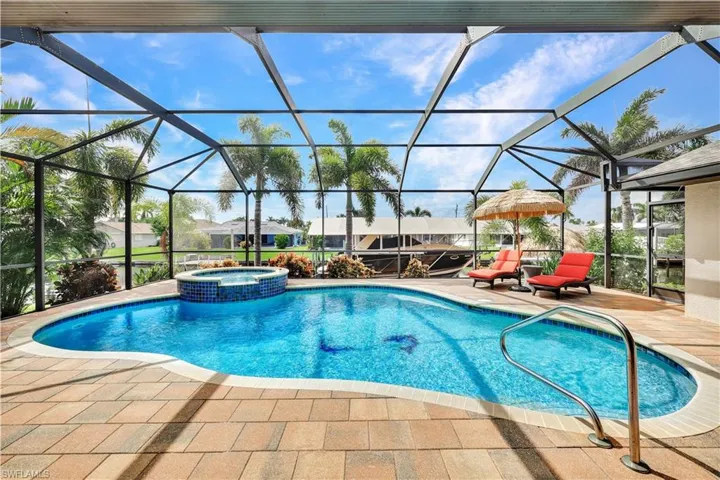 View of pool with an in ground hot tub, a patio, and a lanai