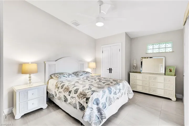 Tiled bedroom with access to the pool area through sliding doors