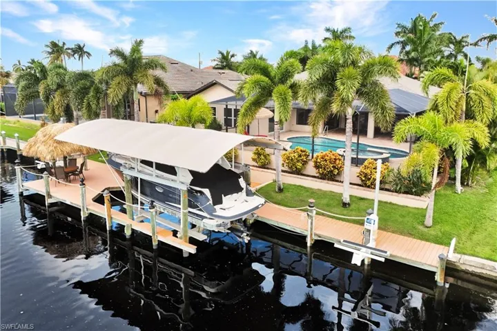 View of dock with a yard and a water view