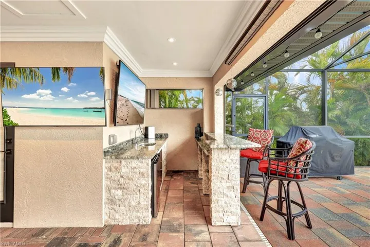 View of patio featuring exterior kitchen, an outdoor wet bar, a grill