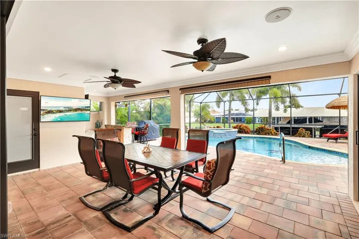 View of swimming pool featuring a patio, a lanai, and ceiling fan