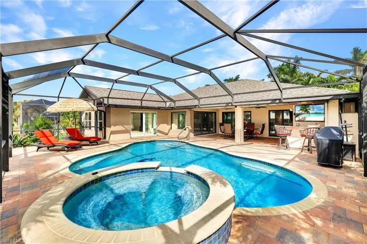 View of pool featuring an in ground hot tub, a patio area, and a lanai