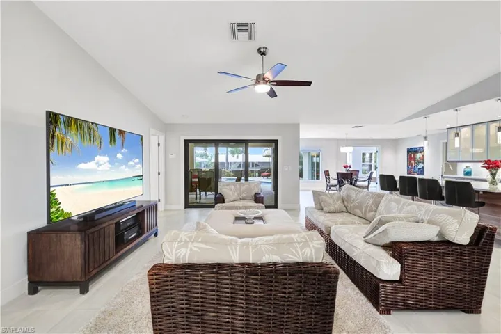 Living room featuring light tile patterned floors, lofted ceiling, and ceiling fan