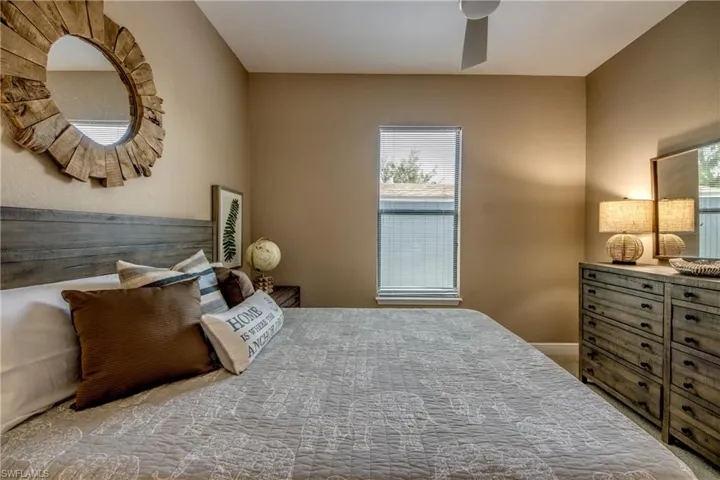 Carpeted bedroom featuring ceiling fan
