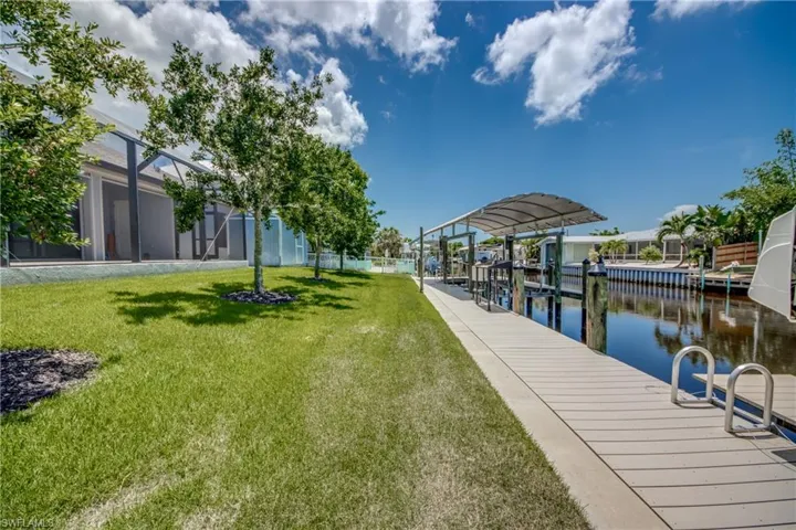 View of dock featuring a water view and a lawn