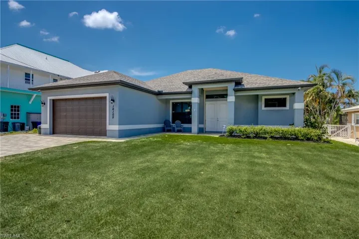 View of front of home featuring a front yard and a garage