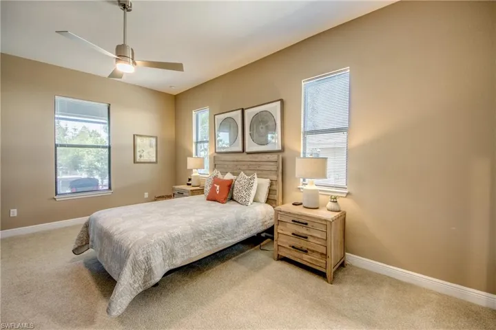 Carpeted bedroom featuring ceiling fan