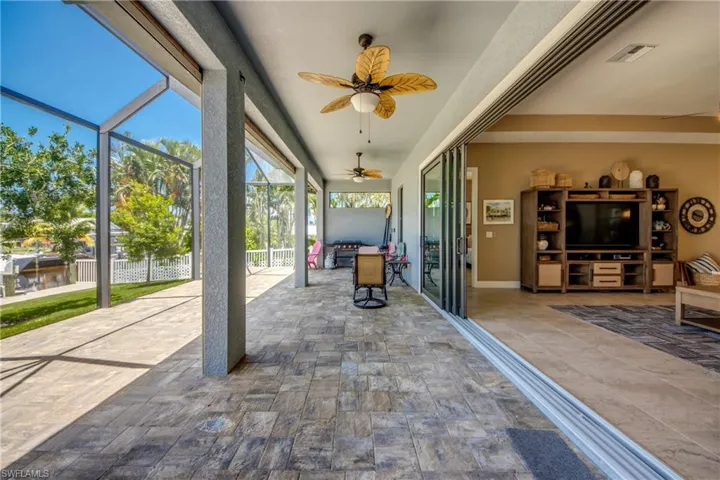 View of patio featuring ceiling fan and a lanai