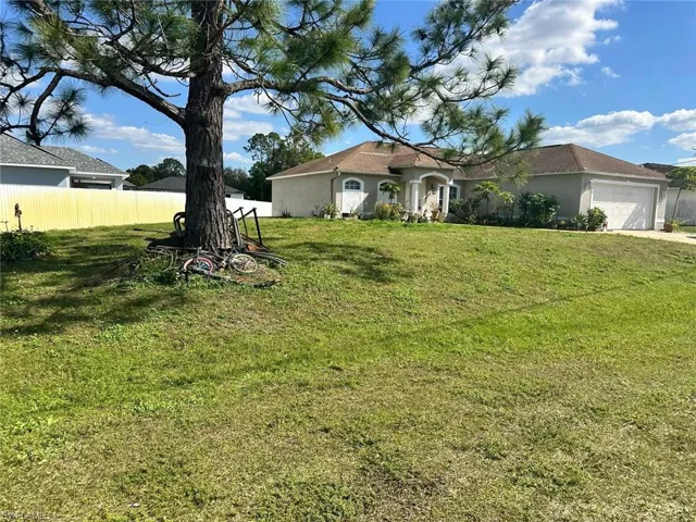 View of front of house with a garage and a front yard