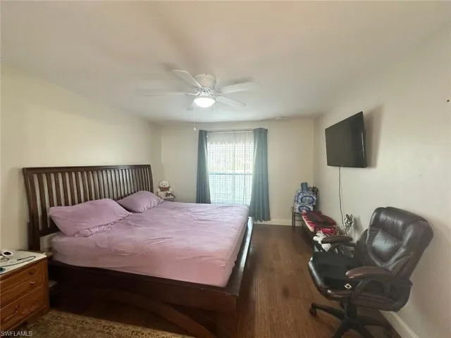 Bedroom with ceiling fan and dark hardwood / wood-style flooring