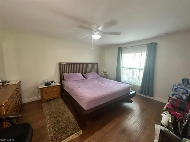 Bedroom with dark hardwood / wood-style floors and ceiling fan