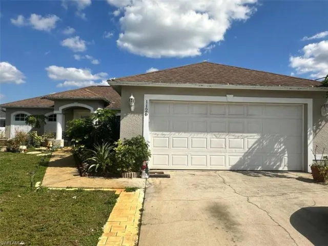 View of front of property with a garage and a front yard