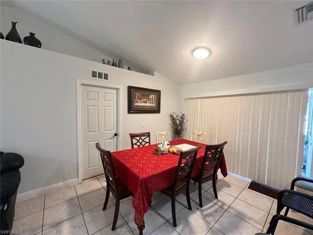 Dining space featuring lofted ceiling and light tile patterned floors