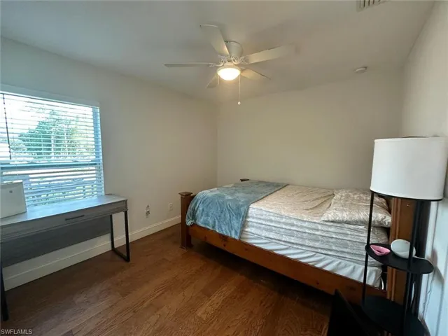 Bedroom with dark wood-type flooring and ceiling fan