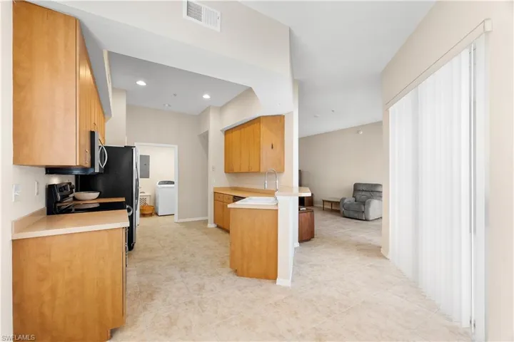 Kitchen featuring sink, light tile floors, and kitchen peninsula