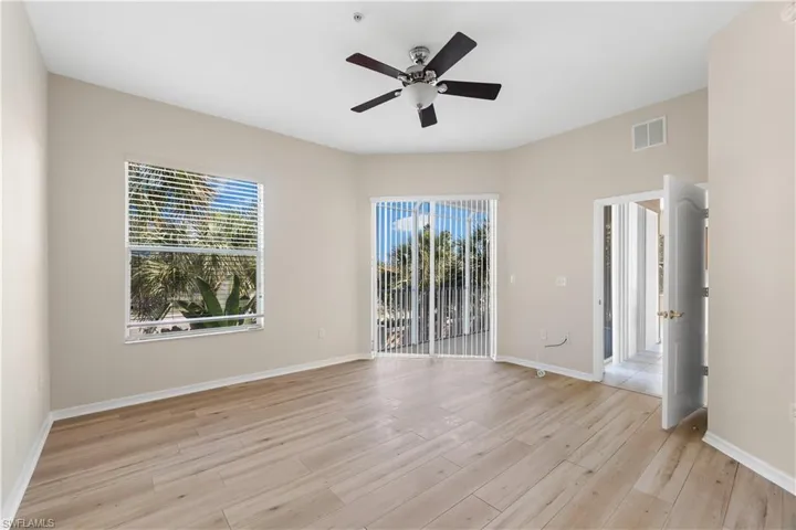 Empty room with ceiling fan and light hardwood / wood-style flooring