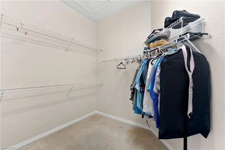 Spacious walk in closet with carpet flooring