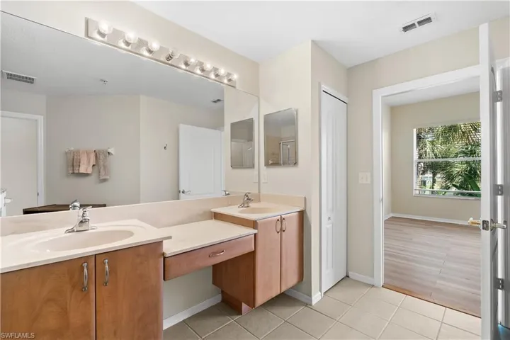 Bathroom featuring dual sinks, tile floors, and large vanity