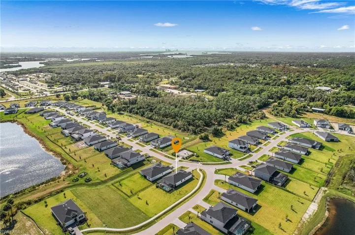Aerial overview of property's location featuring a nearby body of water and nearby suburban area