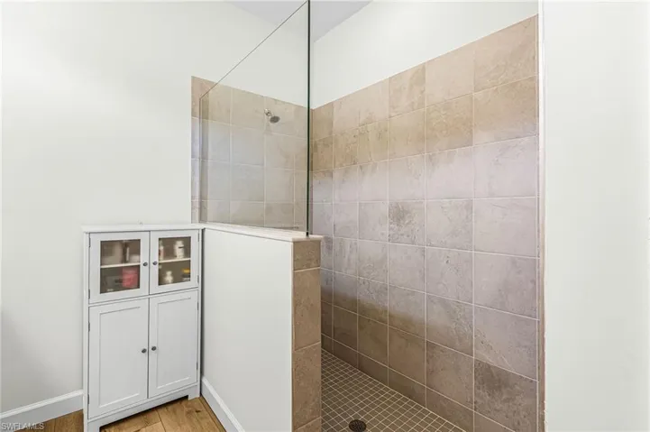 Bathroom with walk in shower and light wood-type flooring