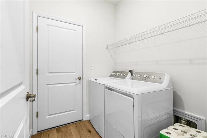 Laundry room featuring light wood finished floors and washer and dryer