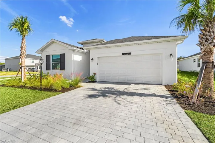Single story home with decorative driveway, stucco siding, and an attached garage