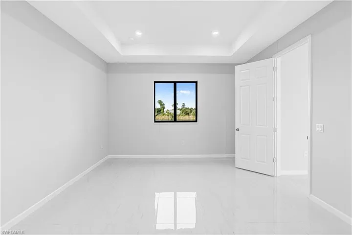 Unfurnished room featuring a raised ceiling and recessed lighting
