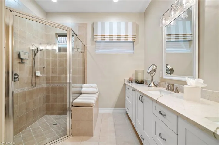 Bathroom featuring a shower with door, tile patterned flooring, and double sink vanity