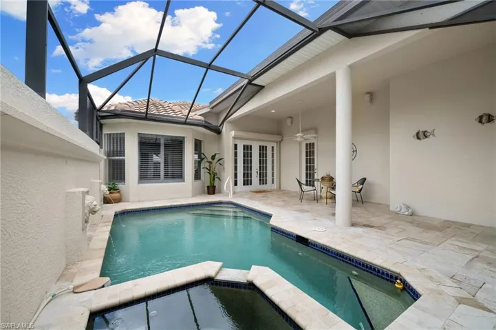 View of swimming pool featuring a patio, ceiling fan, french doors, and glass enclosure