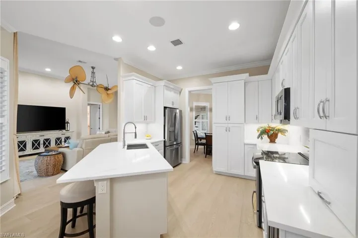 Kitchen featuring appliances with stainless steel finishes, light hardwood / wood-style flooring, white cabinetry, and sink