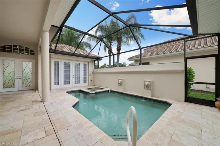 View of pool featuring an in ground hot tub, glass enclosure, french doors, and a patio area