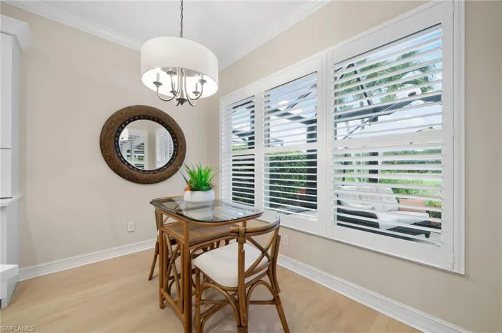 Dining space with a chandelier, crown molding, and light wood-style tile floors