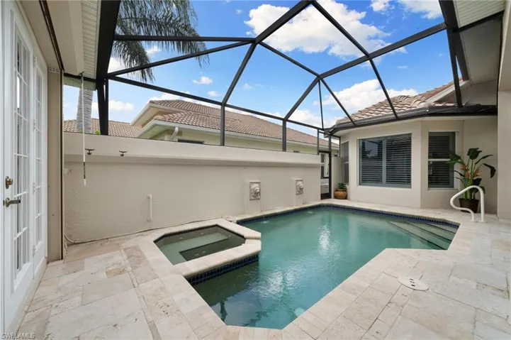 View of swimming pool with a patio area, an in ground hot tub, and a lanai