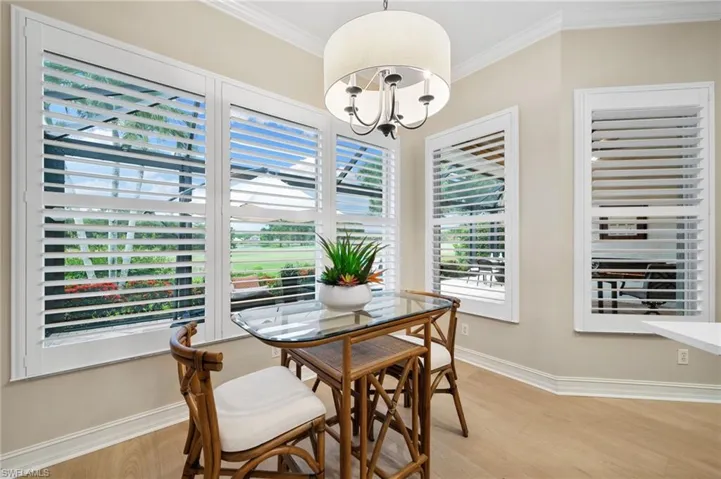 Dining area featuring light hardwood / wood-style flooring, a notable chandelier, and ornamental molding