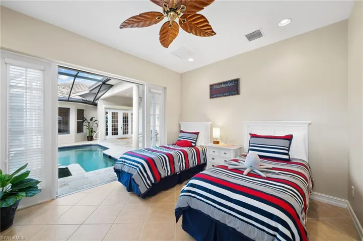 Tiled bedroom featuring ceiling fan and a skylight