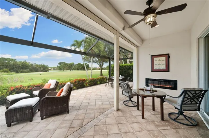 Outdoor panoramic screened in lanai featuring ceiling fan & electric fireplace