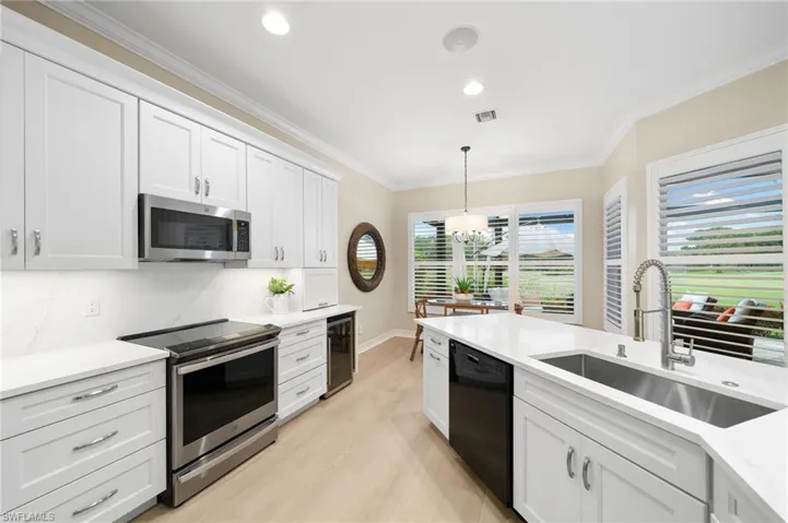 Kitchen featuring ornamental molding, sink, light hardwood / wood-style flooring, and stainless steel appliances