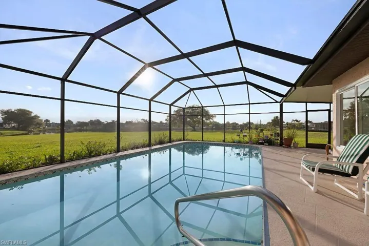 Swimming pool with a sunroom, a yard, and glass enclosure