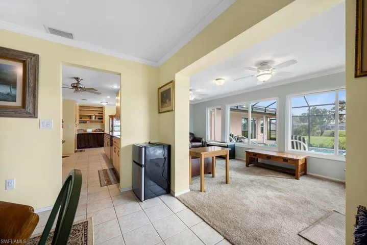 Hall featuring crown molding, light tile patterned floors, and light carpet