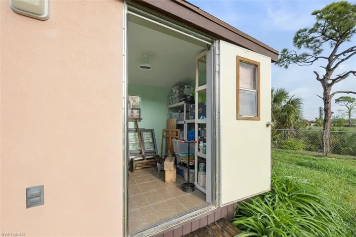 Doorway to shed featuring stucco siding