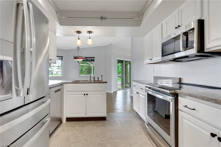 Kitchen featuring appliances with stainless steel finishes, white cabinetry, and plenty of natural light