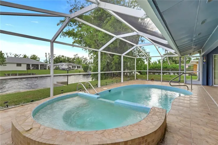 View of swimming pool featuring a patio, a sunroom, a lanai, and a yard