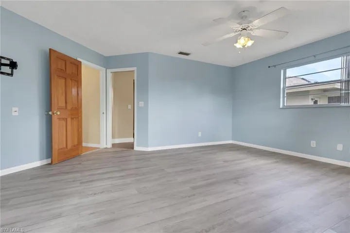 Empty room with light wood finished floors and ceiling fan
