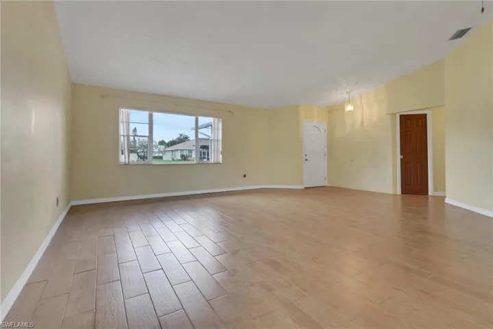 Unfurnished room featuring light wood-style floors and a textured ceiling