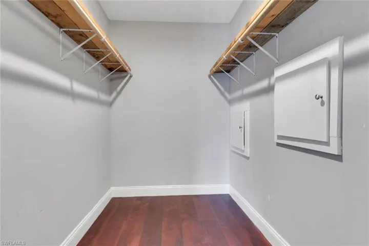 Walk in closet featuring dark wood-type flooring