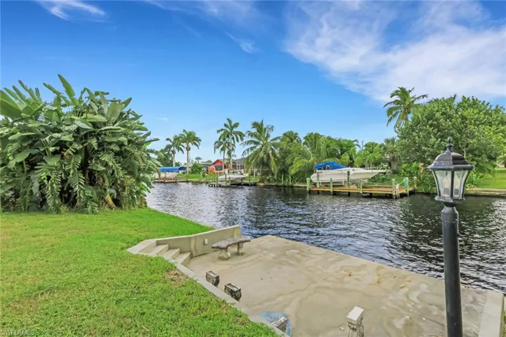 Dock area with a water view and a yard
