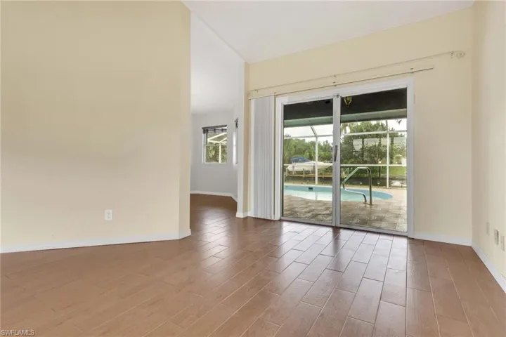 Empty room with wood finished floors and a sunroom