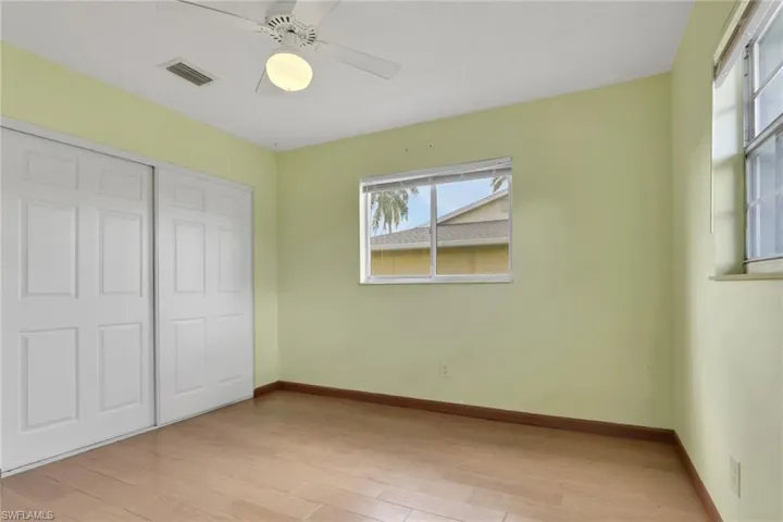Unfurnished bedroom with light wood finished floors, a closet, and a ceiling fan